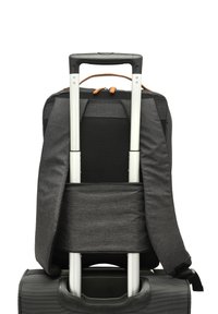 Mochila de color gris oscuro con correas acolchadas, respaldo de malla y acentos naranjas, unida a una maleta negra con ruedas y un asa telescópica.