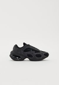 Chaussure de sport noire avec un dessus en mesh et en daim, un design unique avec découpes, et un amorti dans la semelle pour un confort supplémentaire.