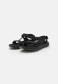 Black sandals featuring fabric straps, adjustable ankle and toe closures, and a textured rubber sole for grip and durability.