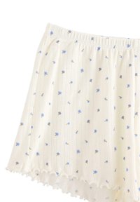 Bomullsshorts med elastisk midja, med blå blommönster på en krämfärgad bakgrund och volangdetalj i nederkanten.