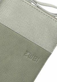 Textured groene en lichtgrijze leren portemonnee met een gestikte naad, voorzien van een geperst logo en gladde accenten in het bovenste gedeelte.