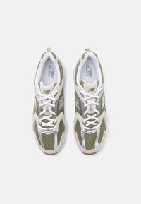 Baskets en maille vert olive avec des accents blancs et argentés. Caractéristiques : lacets, col rembourré et semelle en caoutchouc. Design léger.