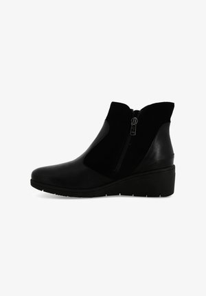 Stivaletti neri alla caviglia realizzati in una combinazione di pelle liscia e camoscio, con una cerniera laterale e un tacco a zeppa per maggiore altezza e stabilità.