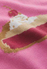 Tessuto a maglia con sfondo rosa e un motivo di torta in crema e marrone, guarnita con una ciliegia rossa. Texture morbida, motivo intricato.