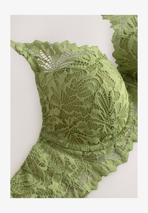 Reggiseno in pizzo verde con motivi floreali, bordi smerlati e texture morbida. Spalline regolabili completano il design dettagliato del tessuto.