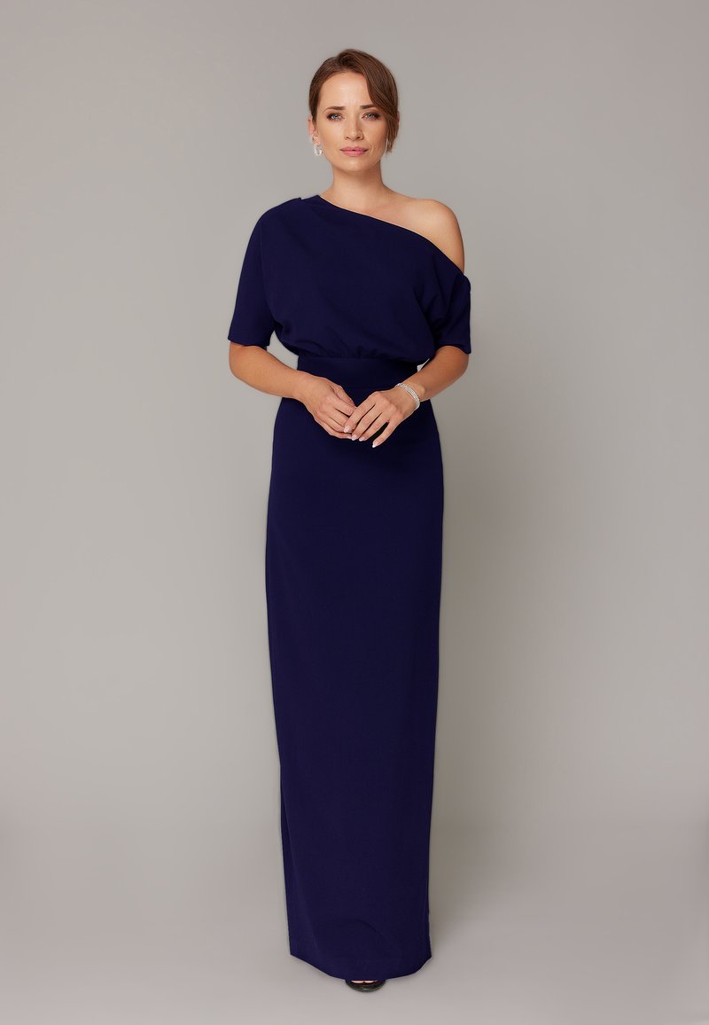 Granatowa sukienka na jedno ramie z dopasowaną talią, zwiewnym dołem i delikatnym drapowaniem. Gładka tekstura, długość do kostek i subtelny połysk.