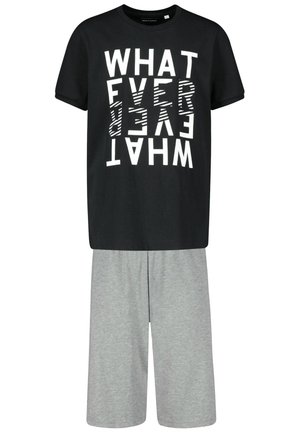 Schwarzes T-Shirt mit fettem, umgekehrtem weißen Textdesign, kombiniert mit hellgrauen, knielangen Shorts aus weichem Stoff.