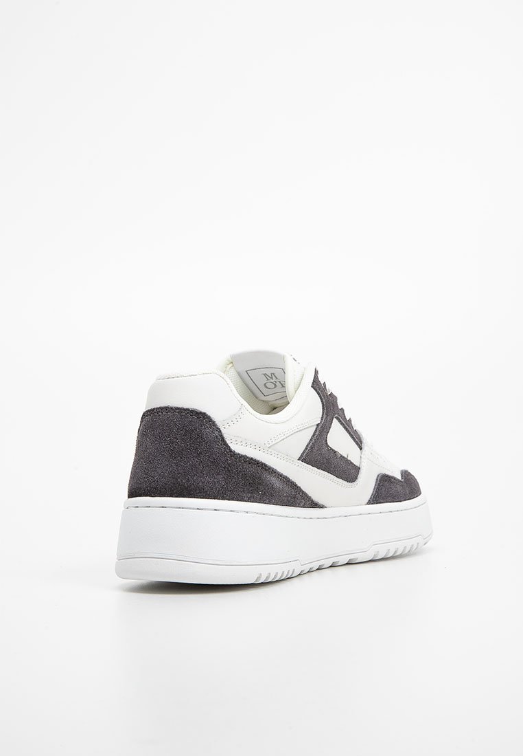 Weiße und dunkelgraue lässige Sneaker mit Wildleder- und Lederpaneelen, dicker weißer Sohle, seitlich von hinten auf einem weißen Hintergrund betrachtet.