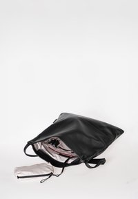 Zwarte leren tote bag met een opvouwbaar ontwerp, een interne ritszak en een verwijderbare lichtgrijze pouch. Soepele textuur en minimale accenten.