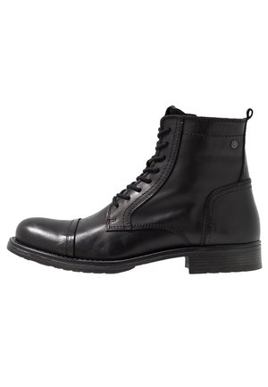 Bottine en cuir noir à lacets avec bout renforcé, détails cousus et petit talon empilé, vue de côté extérieur sur fond blanc.