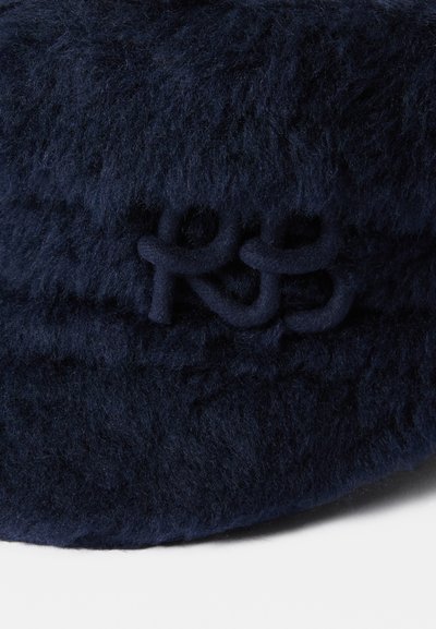 Námornícky modrá, mäkká čiapka s guľatým tvarom. Obsahuje našité iniciály "RS" v rovnakom materiáli. Ideálna na každodenné nosenie.