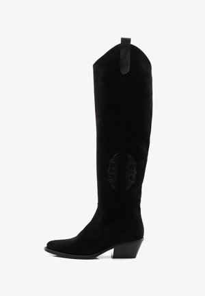 Zwarte suède over-de-knee laarzen met een taps toelopende neus, gesneden details aan de zijkant en een blokhak. Voorzien van een achterste trekhaak.