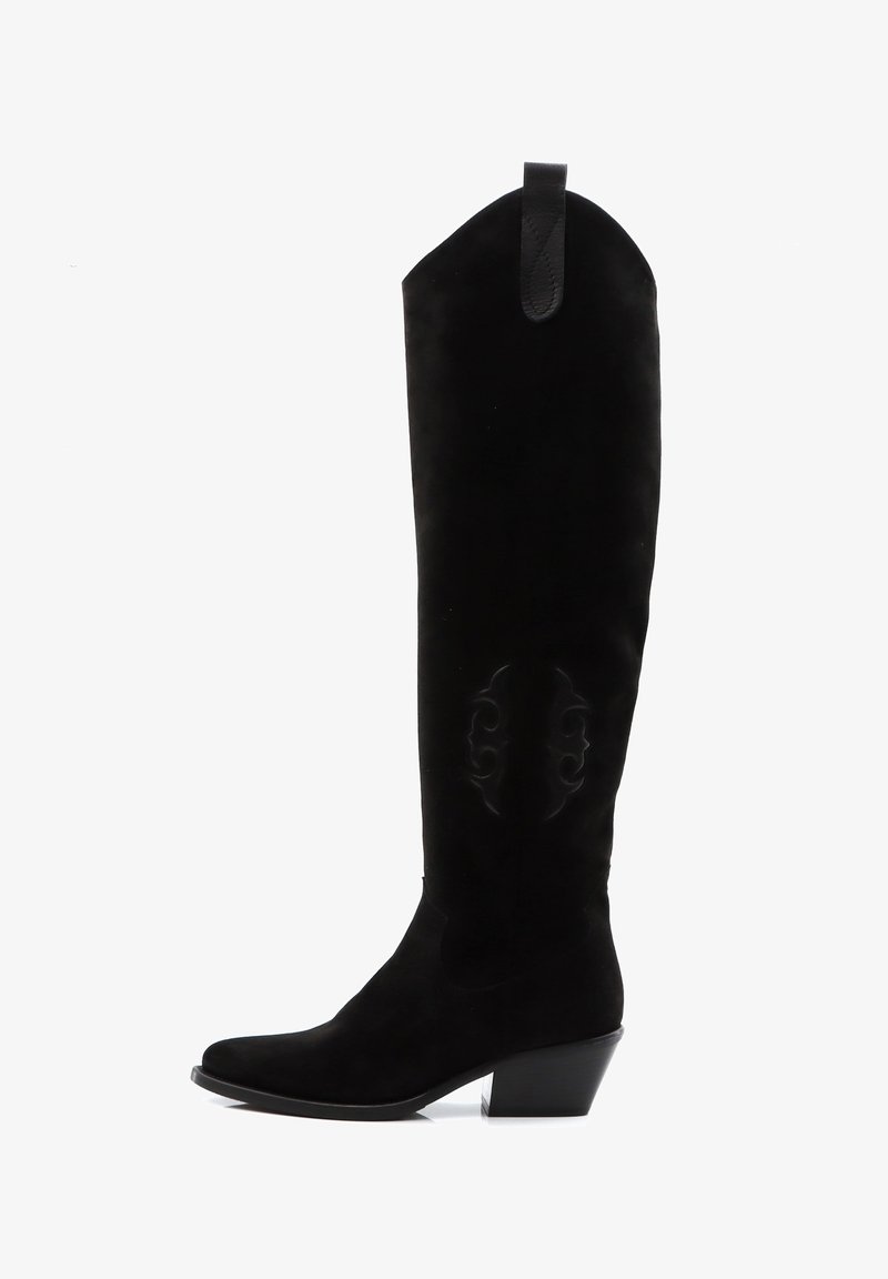 Botas de ante negras por encima de la rodilla con punta ajustada, detalles tallados en el lateral y un tacón cuadrado. Cuenta con una lengüeta trasera.