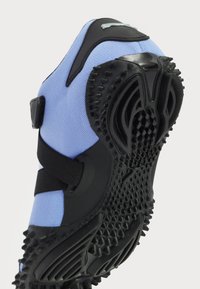 Blå mesh sneakers med sort gummisål og tekstureret greb. Har justerbare stropper for en sikker pasform og et strømlinet design.