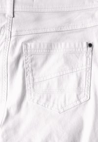 Pantalones de algodón blancos con un solo bolsillo trasero, que cuentan con costuras en contraste y un remache metálico decorativo cerca del borde del bolsillo.