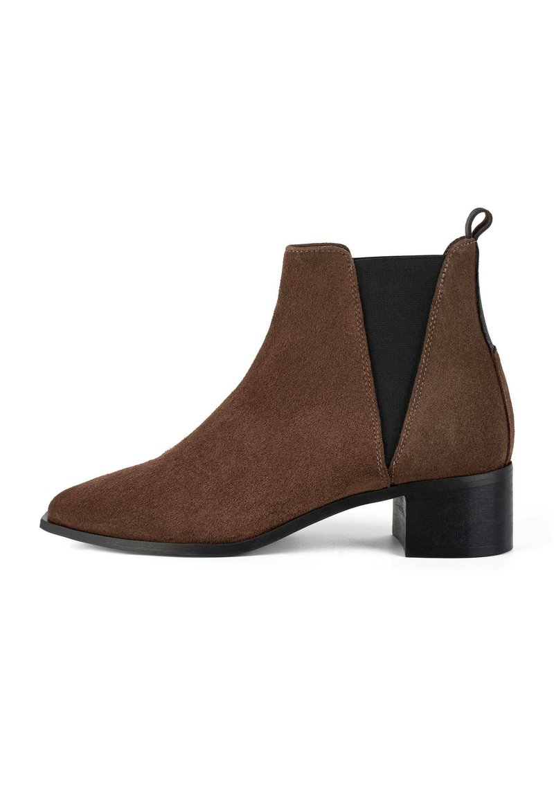 Stivale alla caviglia in suede marrone con punta affusolata, pannelli laterali elasticizzati e tacco a blocco nero basso. Texture morbida con cuciture senza soluzione di continuità.