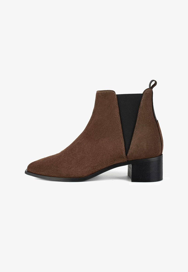Braune Wildleder-Ankle-Boots mit spitzer Zehenpartie, elastischen Seitenpaneelen und einem niedrigen schwarzen Blockabsatz. Weiche Textur mit nahtloser Verarbeitung.