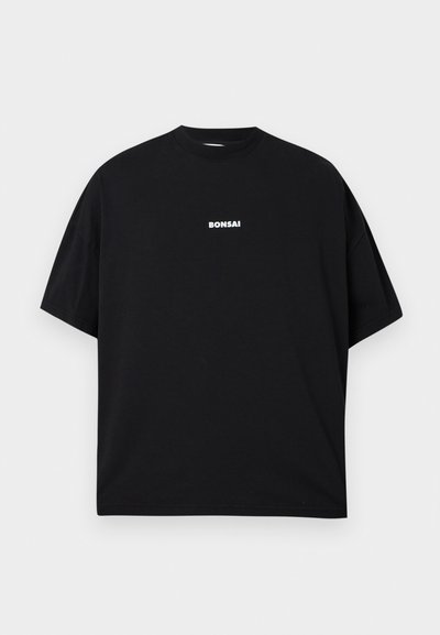 Zwarte oversized T-shirt van katoen. Heeft een ronde hals en korte mouwen, met het woord "BONSAI" in witte tekst op de voorkant.