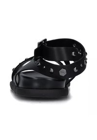 Sandal nero dal design elegante, con accenti borchiati, fibbia regolabile e suola piatta. Realizzata in materiali sintetici, con finitura opaca.