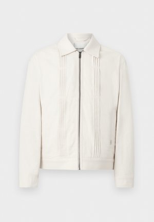 Λευκό μπουφάν με φερμουάρ, γιακά και κάθετες ραφές πιέτας στο μπροστινό μέρος, παρουσιασμένο με φόντο απλό.