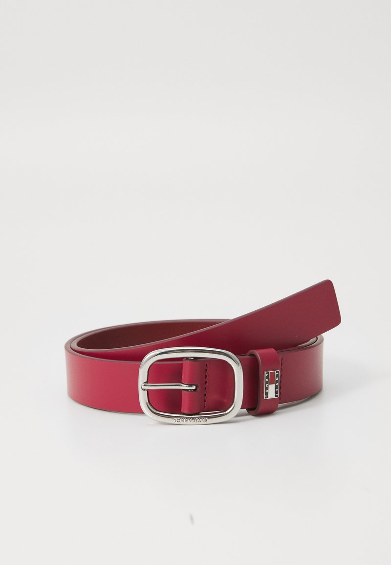 Red leather belt with a silver rectangular buckle, featuring a sleek design and a smooth texture. Includes a logo accent near the buckle.