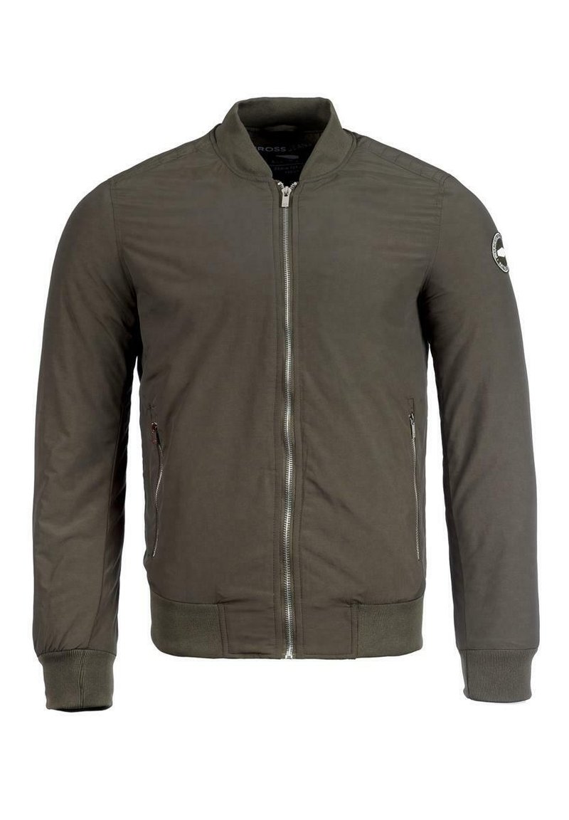 Bomberka w oliwkowej zieleni z zamkiem z przodu, ściągaczami na mankietach i u dołu, płaskim kołnierzem oraz kieszeniami po bokach. Posiada okrągłą naszywkę na rękawie.