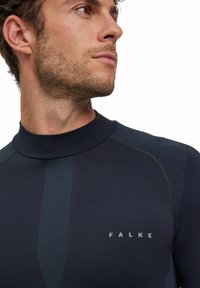 Marineblauwe longsleeve top met hoge kraag, voorzien van textuuraccenten, subtiele merkvermelding en een gestroomlijnd ontwerp voor actieve kleding.