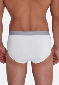 Weiße Baumwoll-Boxershorts mit einem grauen elastischen Bund, glatter Textur und enganpassendem Design, das einen einfachen, klassischen Stil ohne Muster zeigt.