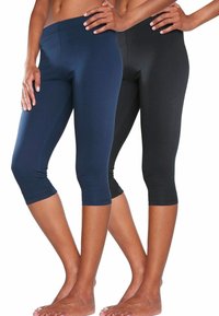 Twee paar nauwsluitende capri leggings, één in marineblauw en één in zwart. Gemaakt van zachte stof, met een elastische tailleband en een knielange snit.