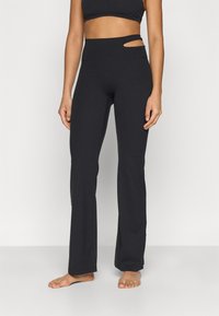 Μαύροι παντελόνες γιόγκα με ψηλή μέση που διαθέτει μοναδικό σχεδιασμό με κοψίματα στο πλάι. Κατασκευασμένοι από ελαστικό, διαπνέον υλικό, με φαρδιά γραμμή.