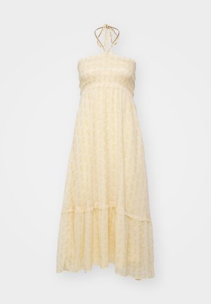 Pitsimekko, joka on valmistettu kevyestä, teksturoidusta kankaasta; vaaleankeltainen kukkakuviolla, rypytetty yläosa ja kaula-aukon narut. Helman kohdalla on röyhelöyksityiskohtia.