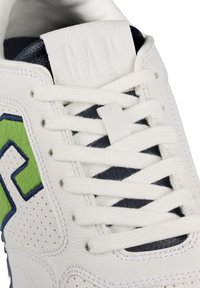 Weiße Ledersneaker mit grünen und blauen Akzenten, strukturiertem Zehenbereich, runden weißen Schnürsenkeln und einem eingeprägten GAP-Logo auf der Zunge.