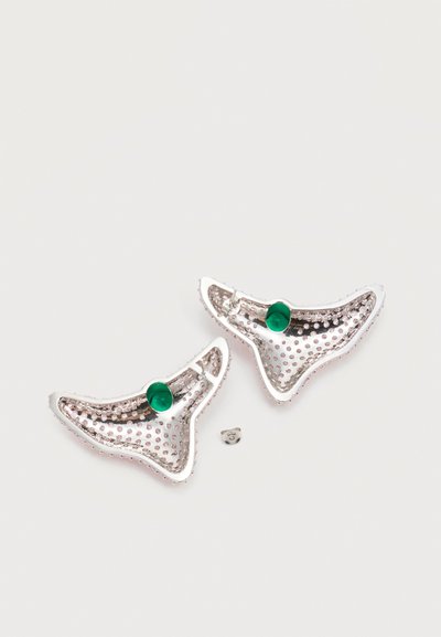 Ασημένια σκουλαρίκια σε σχήμα ημισελήνου με ροζ υφή με κουκκίδες και πράσινες στρογγυλές πέτρες σε απλό ανοιχτό φόντο με ένα πίσω μέρος σκουλαρικιού ορατό.