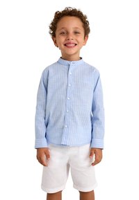 Camisa de manga larga a rayas azul claro con cuello de banda, combinada con pantalones cortos blancos. La camisa cuenta con cierres de botones y puños.