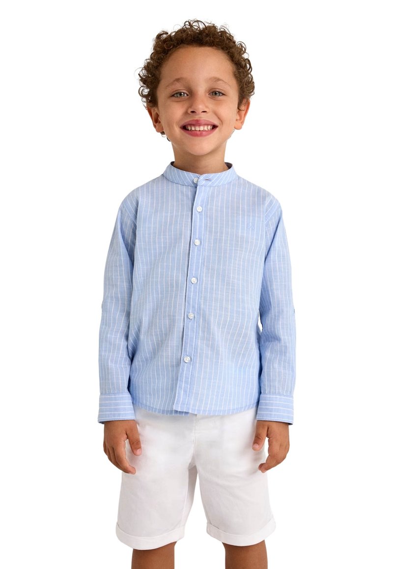 Camisa de manga larga a rayas azul claro con cuello de banda, combinada con pantalones cortos blancos. La camisa cuenta con cierres de botones y puños.