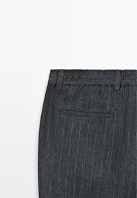 Dark gray pinstriped trousers featuring an elastic waistband, belt loops, and a back pocket. The texture appears smooth and lightweight.