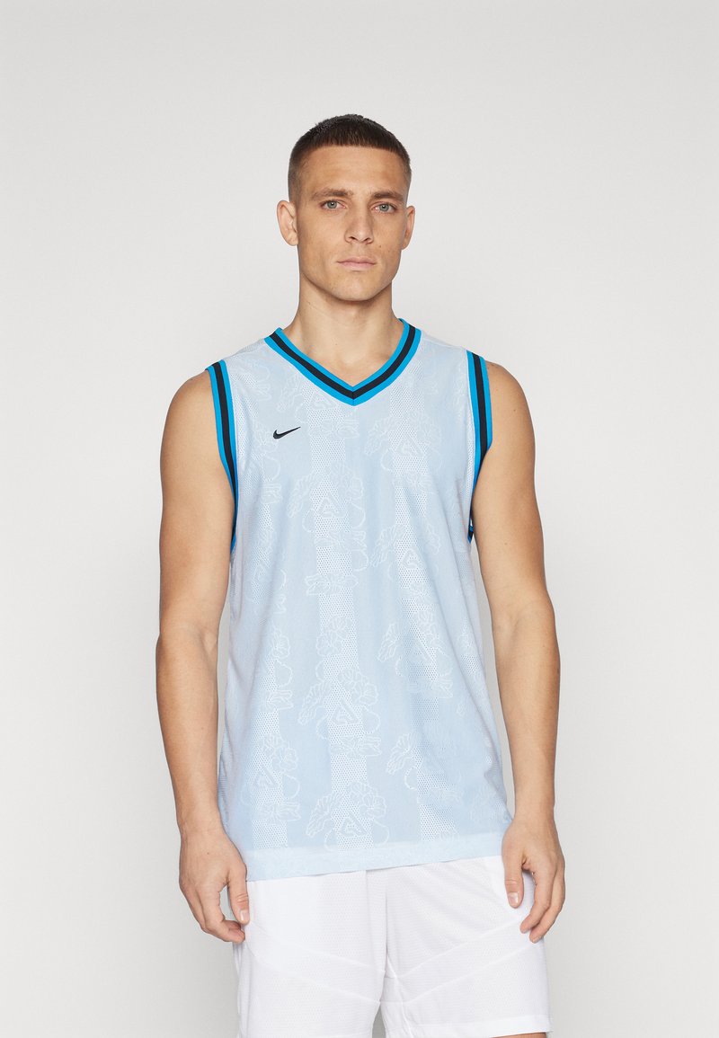 Maillot de basketball sans manches bleu clair avec logo Nike noir, accents noir et turquoise, motif texturé et design en V.