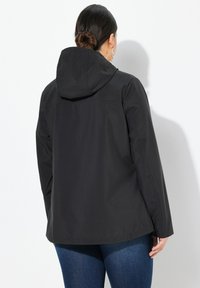Veste noire imperméable avec capuche, design droit et texture subtile. Elle présente une couture au dos et une coupe décontractée.