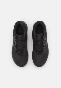Scarpe sportive nere con tomaia in rete, superficie testurizzata, punta rotonda e lacci piatti. Presentano un logo discreto sul lato.