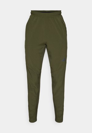 Grønne sportsbukser med en tapered fit, lavet af letvægtsstof, med elastisk talje og diskret logo detaljer på låret.