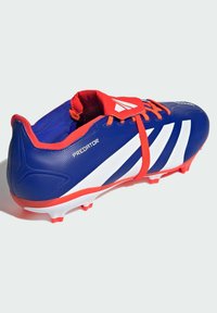Scarpino da calcio blu con strisce bianche e accenti rossi. Tomaia sintetica testurizzata, colletto imbottito e tacchetti bianchi per trazione.
