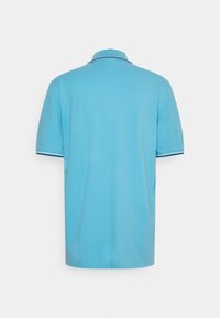 Polo en tissu bleu clair avec une finition unie, arborant un col classique et des accents contrastants bleu marine sur les manches.