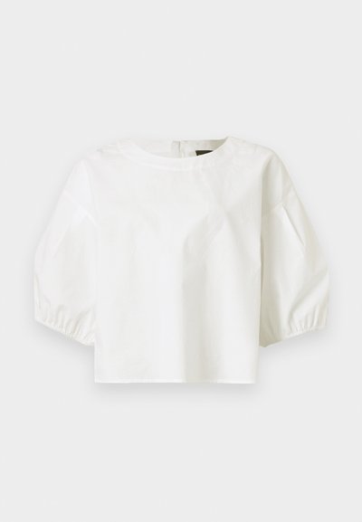 Λευκό γυναικείο μπλουζάκι με στρογγυλή λαιμόκοψη και τριχοτες φουσκωτές μανσέτες, απλό σχέδιο, εμφανίζεται σε γκρι φόντο.