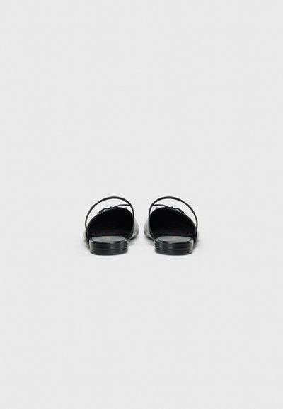 Black leather sandals with open backs, thin straps, and low square heels. Smooth texture with minimal detailing and no visible hardware.