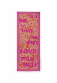 Frotteehandtuch mit einem floralen Muster in Hellrosa auf einem orangefarbenen Hintergrund. Dicke pinke Bordüre mit fettem Text: "Es ist in Ordnung, schlechte Tage zu haben. LIEBE DICH SELBST."