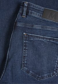 Tmavě modré džíny z denimu s zadní kapsou, kontrastním prošíváním a embosovaným černým koženým logem na pásku.