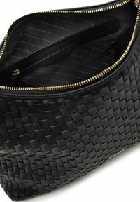 Sac en cuir tressé noir avec une fermeture éclair dorée. L'intérieur comprend une poche zippée et un compartiment doublé avec un motif discret.