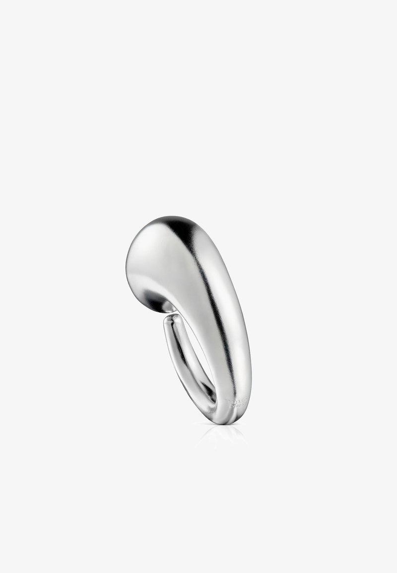 Anillo de metal plateado con un diseño suave y curvado, de forma escultórica y textura reflectante. Estilo minimalista sin adornos adicionales.