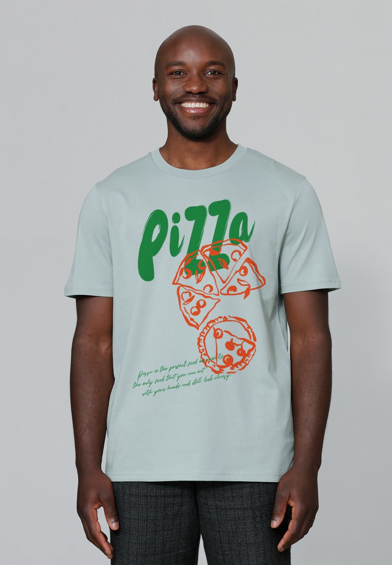 T-shirt en coton bleu clair avec des graphiques de pizza verts et orange et un design de texte. Manches courtes et encolure ras du cou.