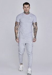 Light gray short-sleeve t-shirt paired with matching cargo joggers, featuring pockets and ribbed cuffs, worn with white athletic shoes.